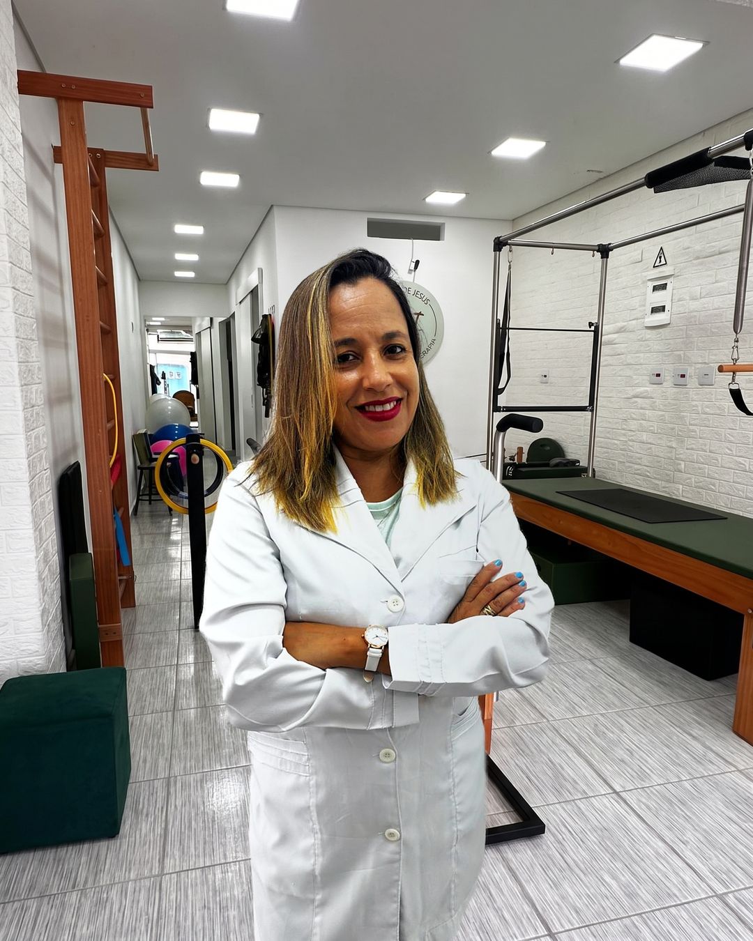 Luizangela de Jesus sorrindo, de jaleco, no estúdio.