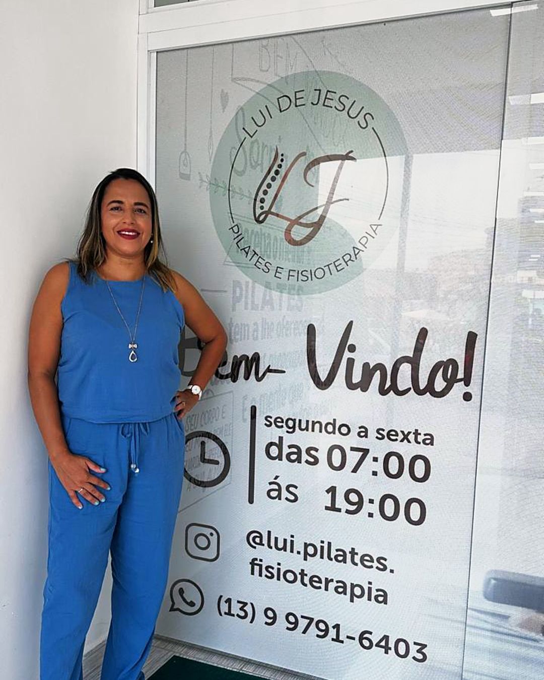 A porta de vidro do estúdio, com a marca Lui de Jesus Pilates e Fisioterapia e o horário de atendimento.